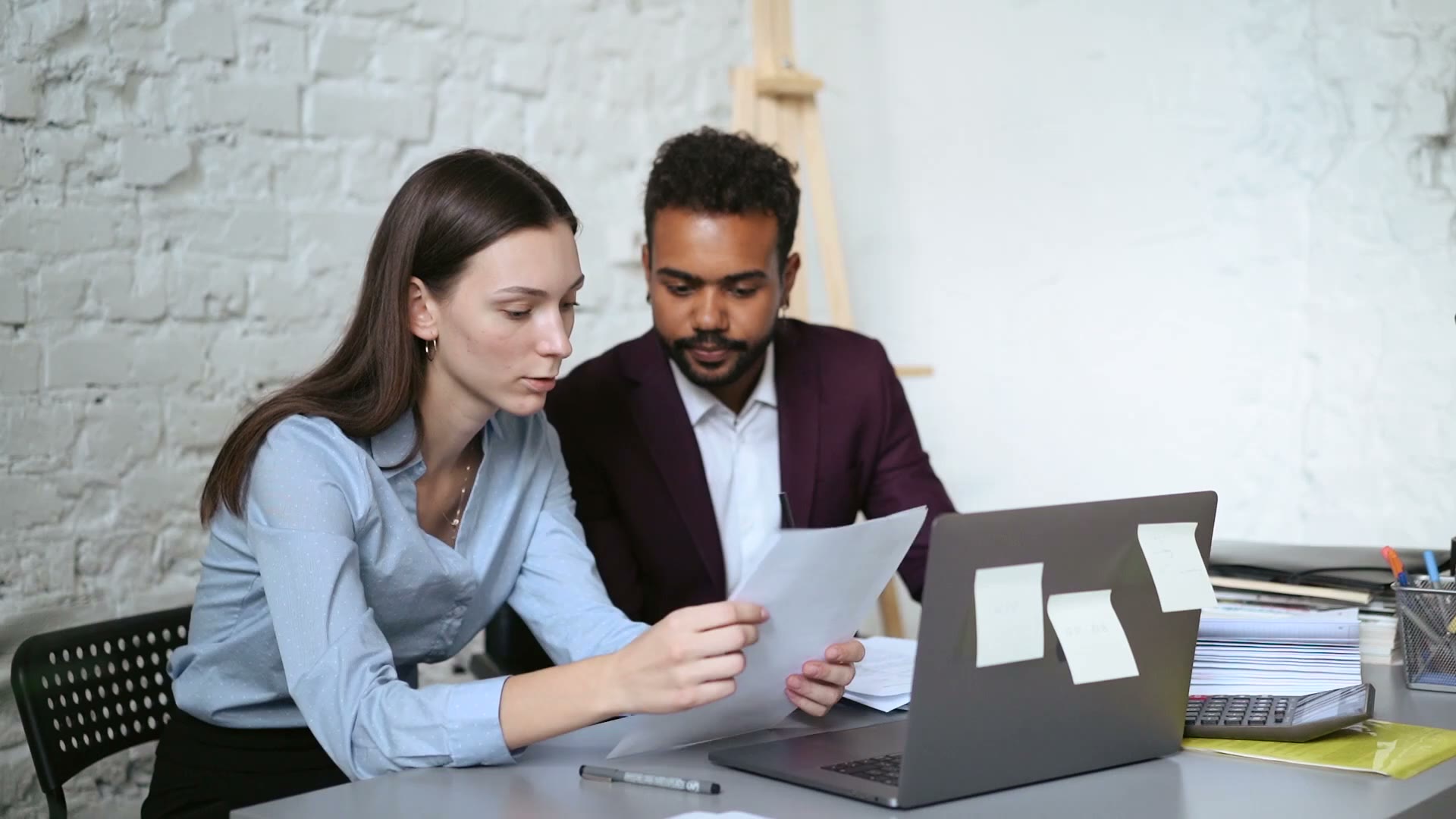 Two colleagues going through figures at a laptop