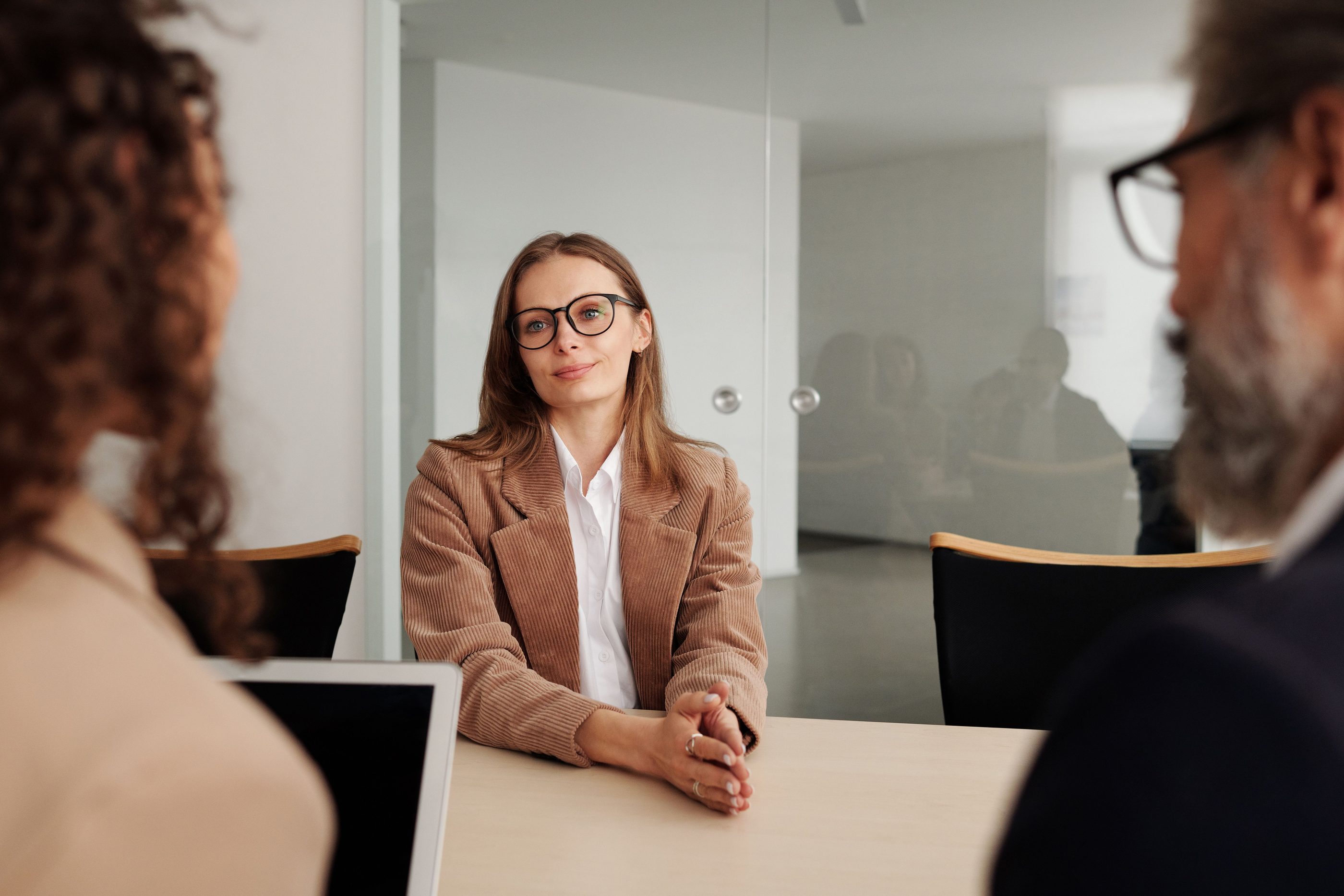 A candidate at a meeting table, seen between two interviewers