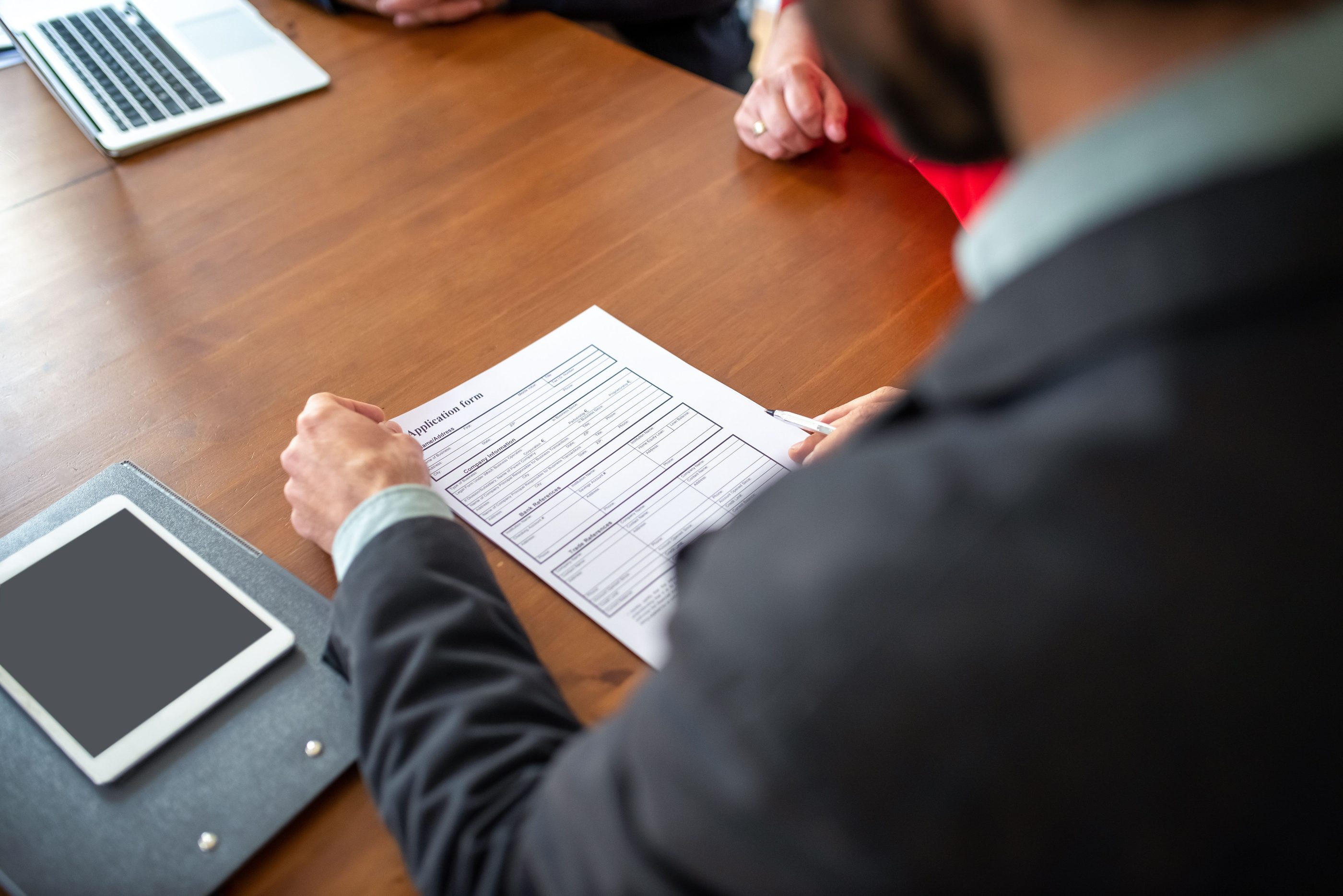 A hiring manager reading an application across a meeting table
