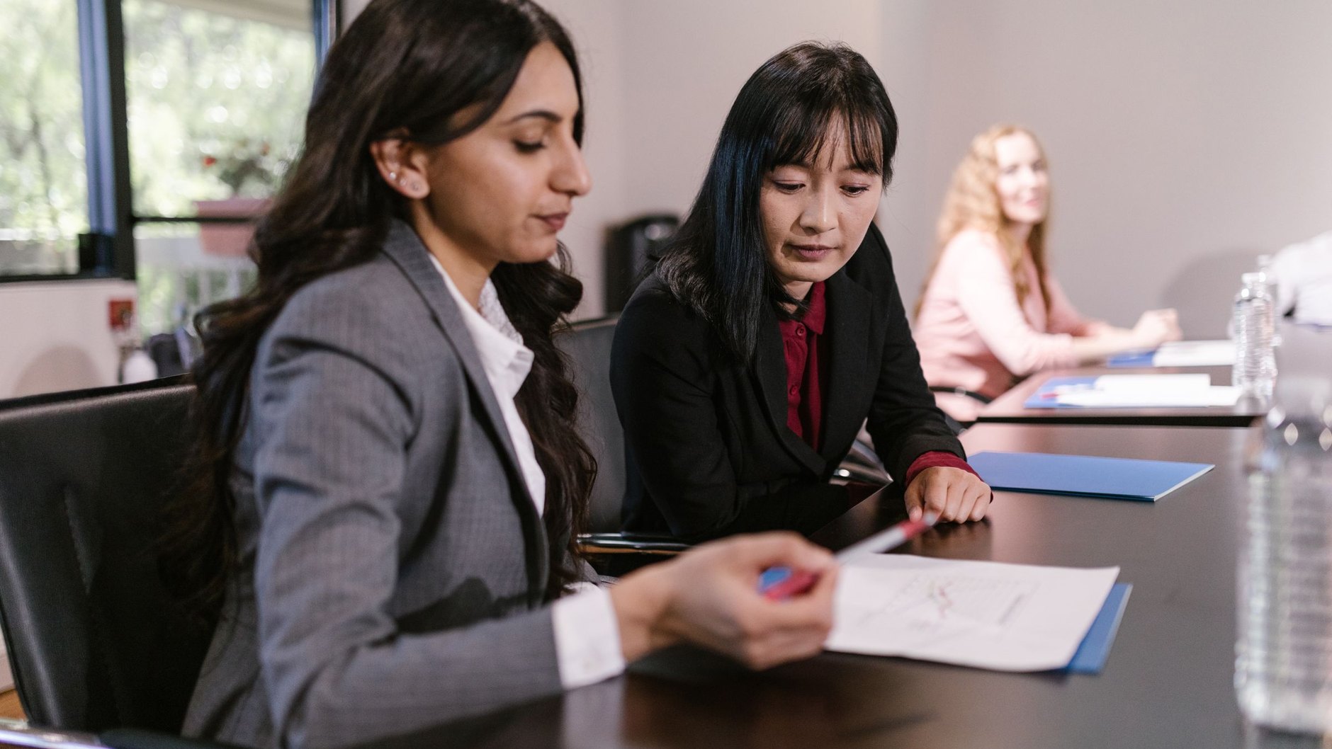 Two colleagues going through documents at a meeting table