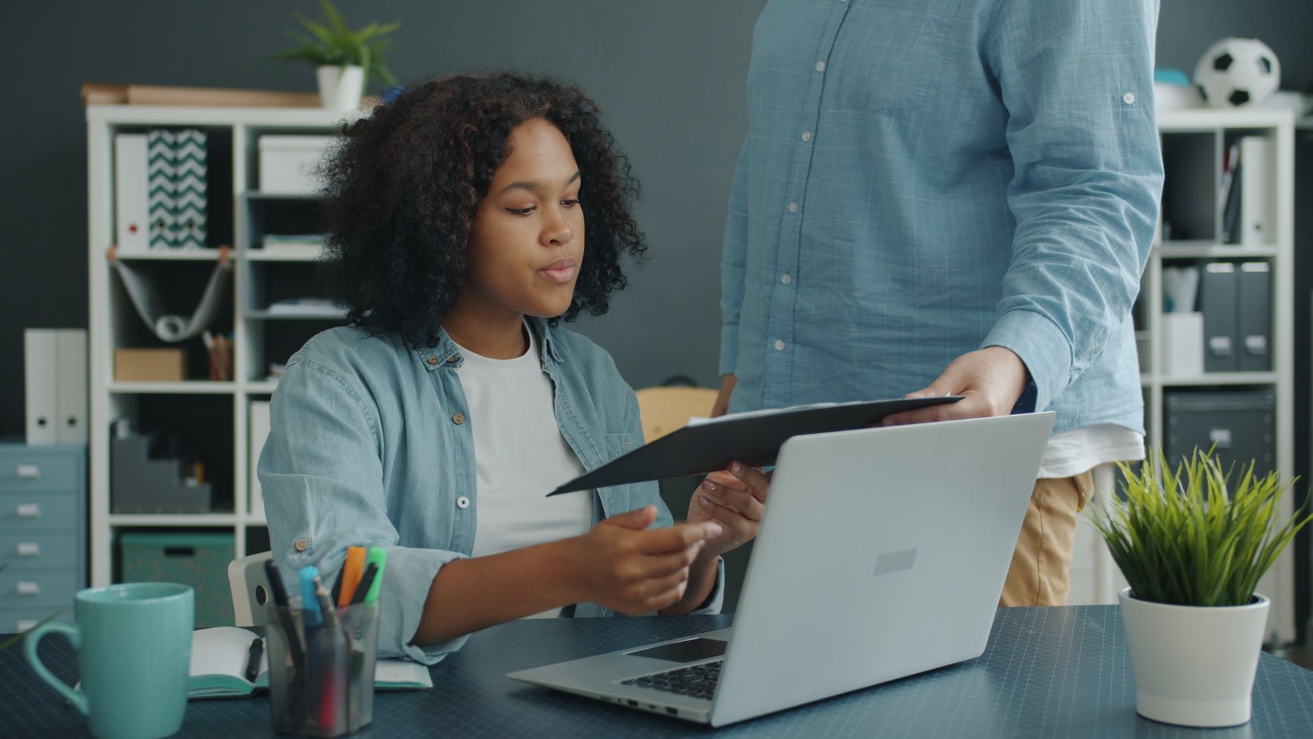 A colleague walking a new hire through their work